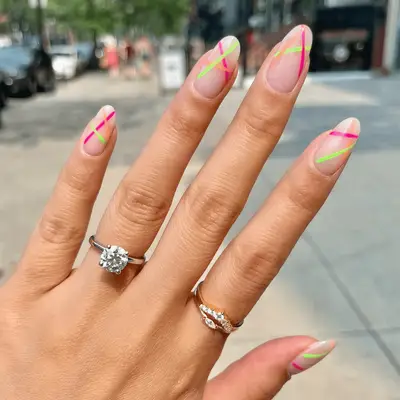 Pink and green nails with flower, yin/yang, and swirl designs