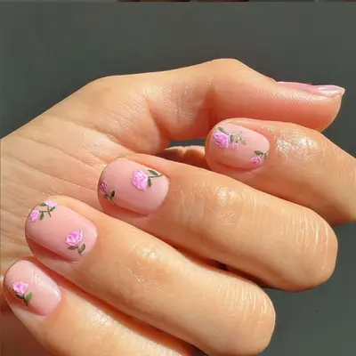 Nude nails with pink roses and green stems.