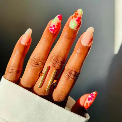 Pink, green, and orange floral nail design with solid neutral accent nails