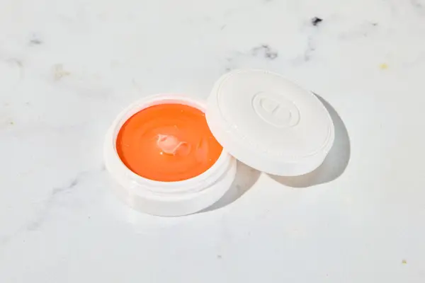 Dior Crème Abricot Nail Creme sitting on a marble counter