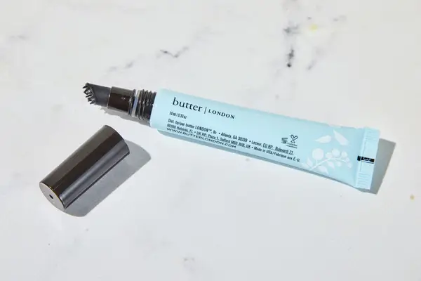 Butter London QuickFix Moisturizing Cuticle Balm sitting on a marble counter