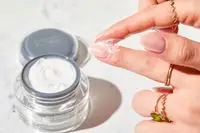 A person applying Dermelect Rejuvenail Treatment to their nail bed