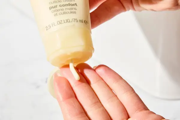 Person dispenses Clinique Deep Comfort Hand and Cuticle Cream into their hand