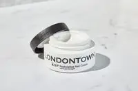 An open container of Londontown Restorative Nail Cream on a marble counter