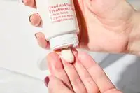Person dispenses Clarins Hand and Nail Treatment Cream into their hand