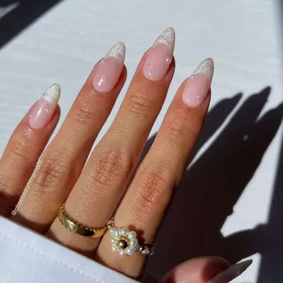 Close-up of manicure with mother of pearl French tips and pearl accents