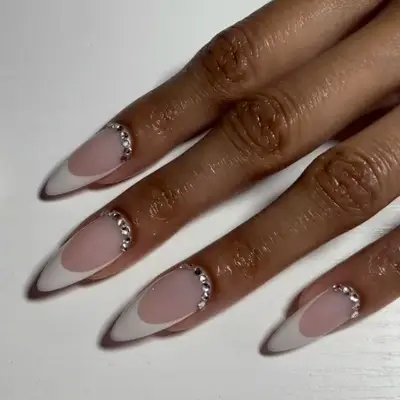Close-up of manicure with bedazzled cuticles and white French tips