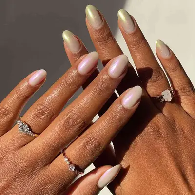 Hands with a white base coat and pink chrome finish on one hand and a gold chrome finish on the other.