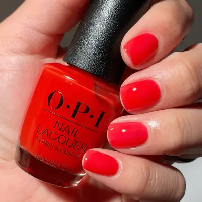model with coral jelly nails holding an OPI bottle