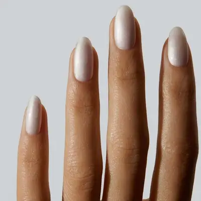 A white satin pearl manicure, viewed close to the fingertips