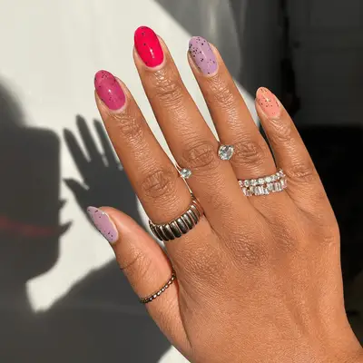 Manicure with purple and silver swirled polishes and sparkle and wave designs