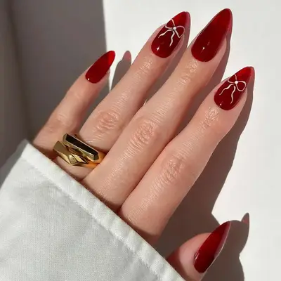 Red jelly nails with white bow accents - MYM Beauty February Nail Ideas