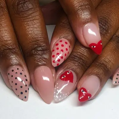 Pink manicure with black and red dot and heart designs