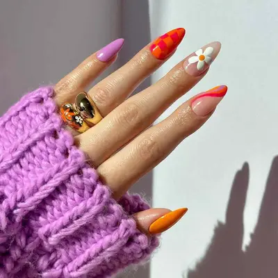 A mismatched manicure with daisy and checkerboard nails