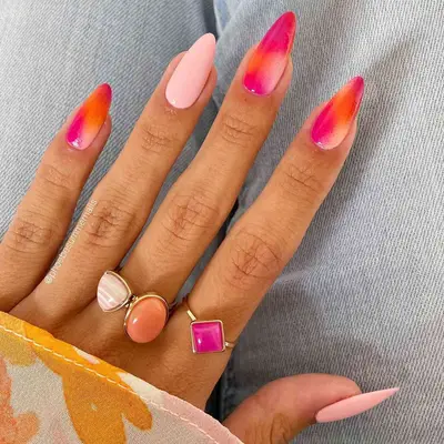 A sunset-colored manicure with pinks and oranges in ombre