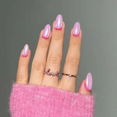 A manicure with a sparkly pink base and hot pink cuticles
