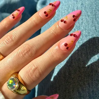 A French manicure with pink tips and cherry accents