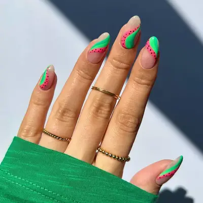 a manicure with abstract green and pink swirls that look like watermelon