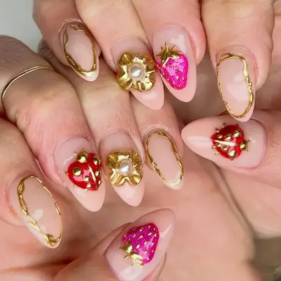 a glam manicure with gold, heart, and cherry accents