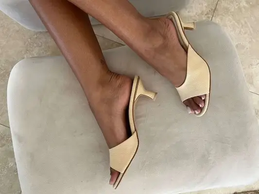 Close-up of pedicured feet wearing ivory open-toed heeled sandals