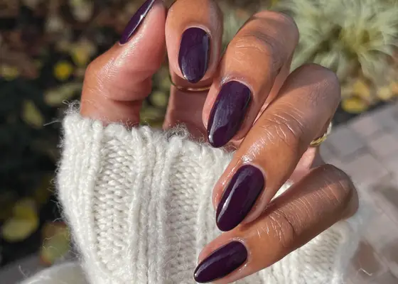 Hand folded in with an exposed white knit sweater with dark plum almond nails