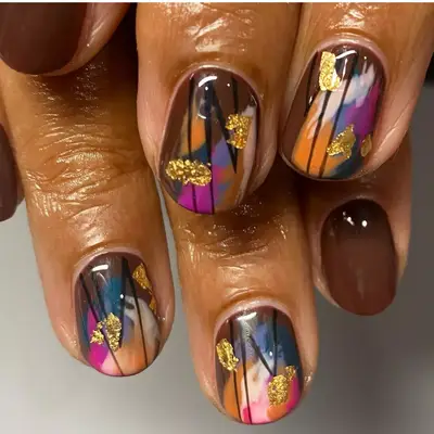 abstract art with gold leaf on short nails and brown accent nails