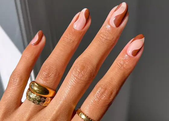 Long round nails with brown swirls and negative space manicure