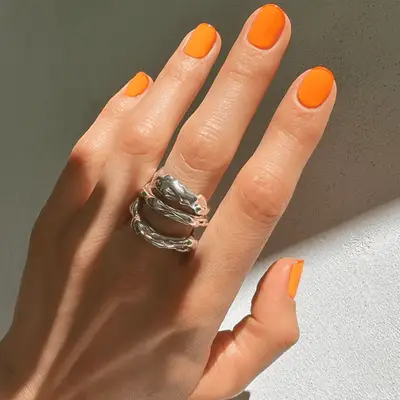 Short orange nails with micro pink French tips