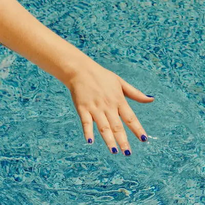 hand on the surface of pool water