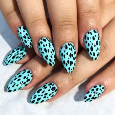 Blue cheetah-print manicure on short stiletto-shaped nails.