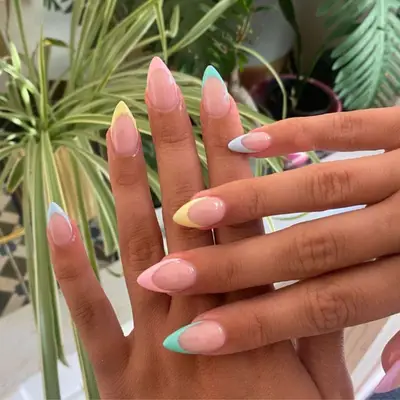 French manicure with multicolored tips and stiletto-shaped nails.