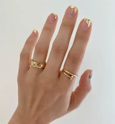 Close up of a gold foil manicure on square-shaped nails