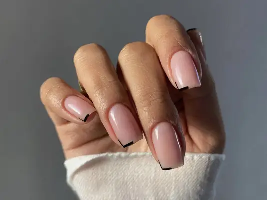 Square nails in a neutral color with subtle black tips