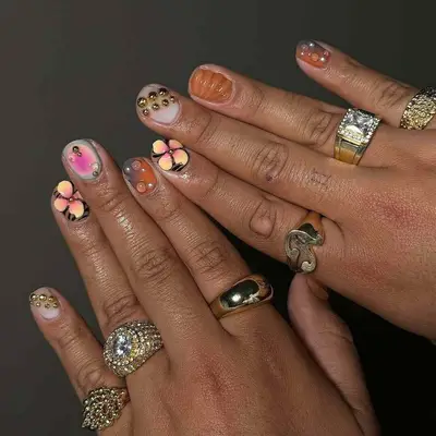 Hands with intricate nail art and gold rings