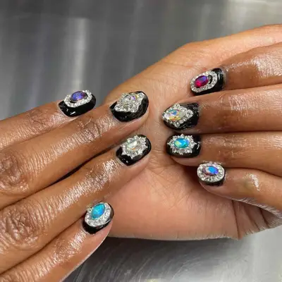 Close-up of hands with decorative gemstone nail art