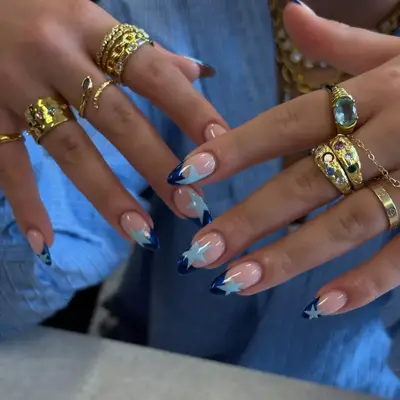 dark blue french tips nails with light blue stars