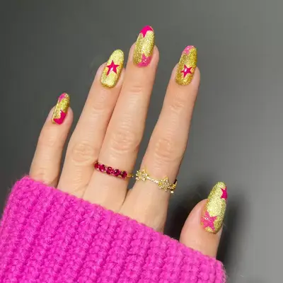 sparkly gold nails with pink stars