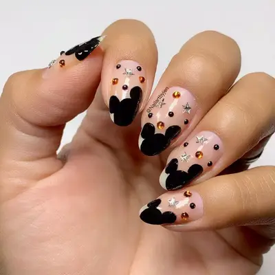 Clear nails with Mickey Mouse ear designs and bedazzling