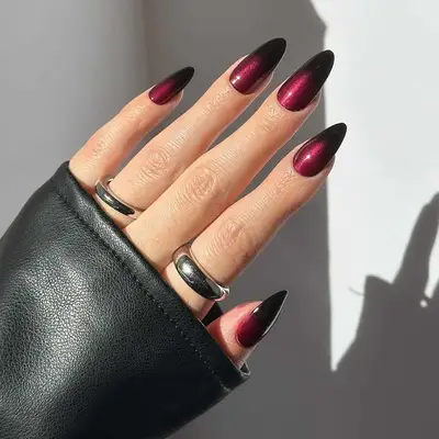 Long almond-shaped nails with a burgundy to black ombre fade