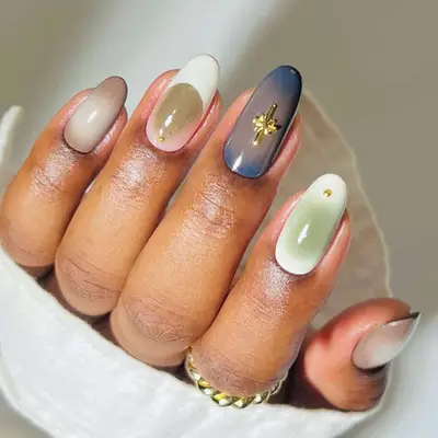 Aura manicure featuring shades of taupe, cream, sage, and slate grayish-blue with gold metallic accents