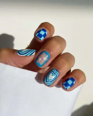 A French manicure with silver tips and zodiac decals