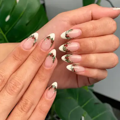 Nails with a white French manicure and holly wreath details.