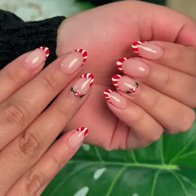 Candy cane French manicure with holly nail art.