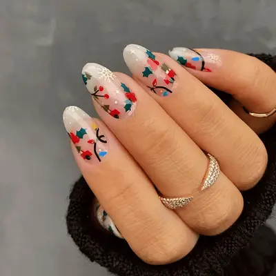 Nude oval nails with a mix-and-match holiday motif, including string lights, cars, and holly leaves.