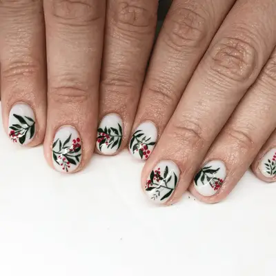 Short milky white nails with a continuous holly design on the nails.