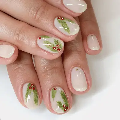 Nude short nails with holly leaf and berry details.