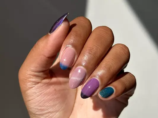 A neutral mauvy and purple Skittle manicure