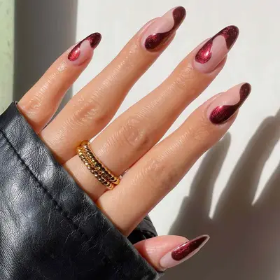 Manicure with burgundy swirl metallic nail designs