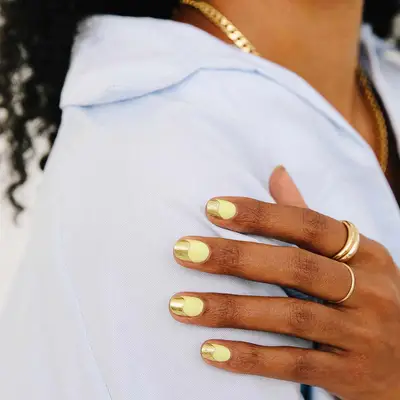 Half-yellow, half-gold metallic nails with wavy dividing line