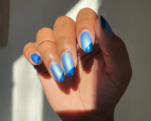 Light blue metallic nails with dark blue corner accent detail